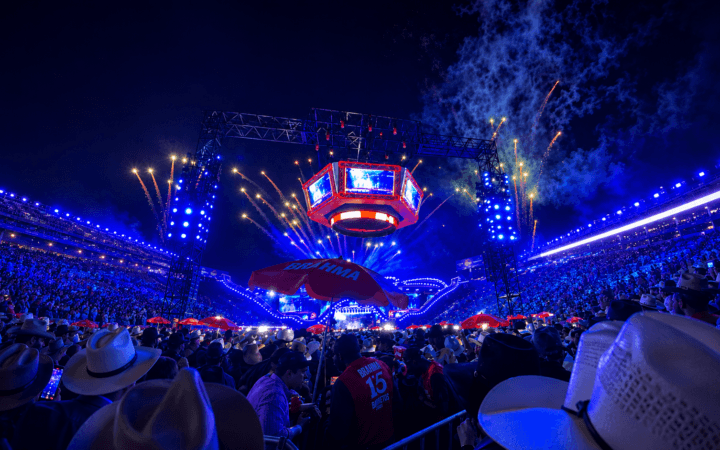 Ilustração por IA representa arena lotada durante a Festa do Peão de Barretos, com shows e fogos de artifício.