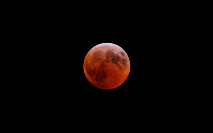 Ilustração por IA mostra Lua avermelhada durante eclipse lunar parcial semelhante ao previsto para agosto de 2026.