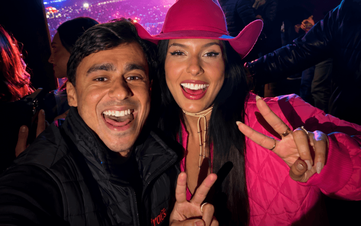 Foto real editada mostra duas figuras públicas posando juntas em evento noturno, com expansão lateral por IA para uso editorial.