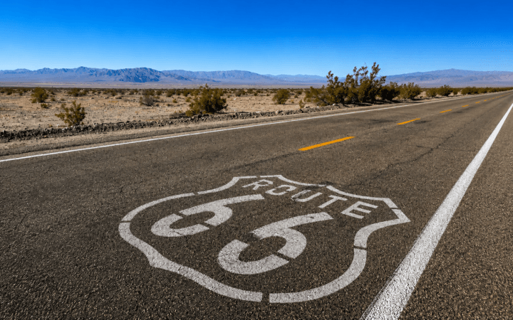 Ilustração de IA mostra a Route 66 atravessando paisagem desértica em referência ao centenário da estrada.