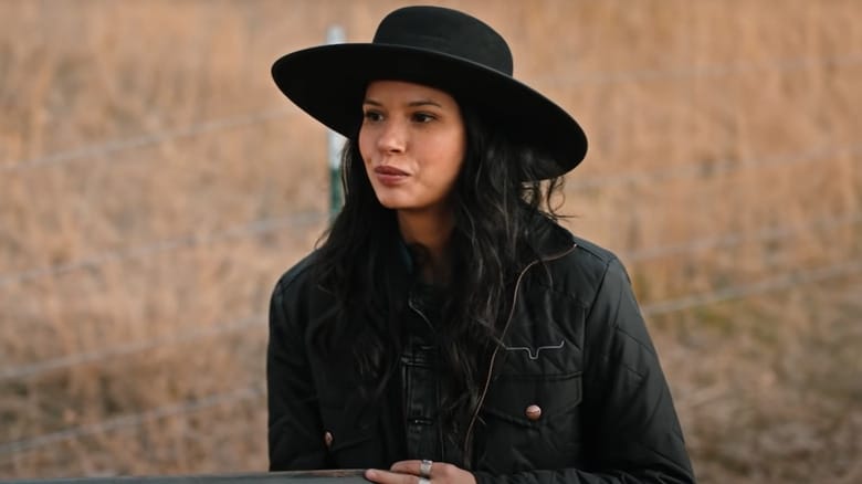Personagem aparece com chapéu preto em frame real de Yellowstone, em cenário rural característico da série.