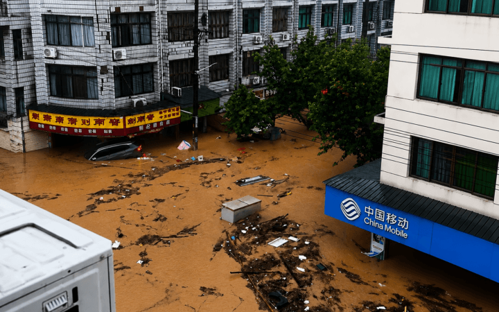 Frame real aprimorado por IA mostra rua tomada por água e detritos durante enchentes em Ningde, na China.